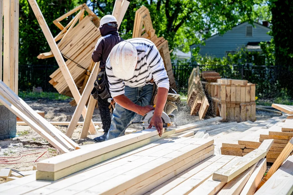 Worker cutting lumber at a residential building site