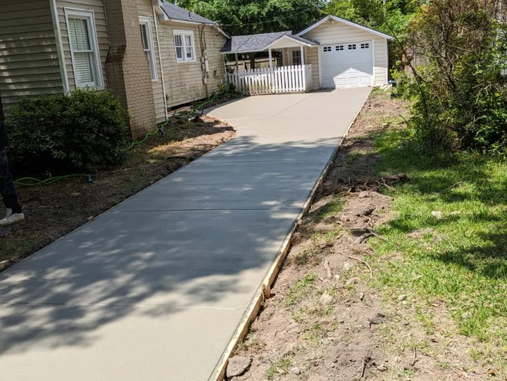 Long concrete walk leading to a white garage