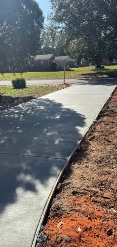 Narrow concrete walkway beside graded dirt