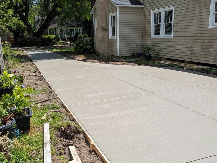 New concrete sidewalk running along the side of a home