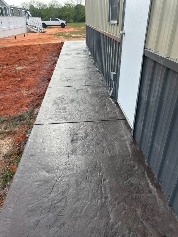 Textured stamped concrete walkway beside a metal building